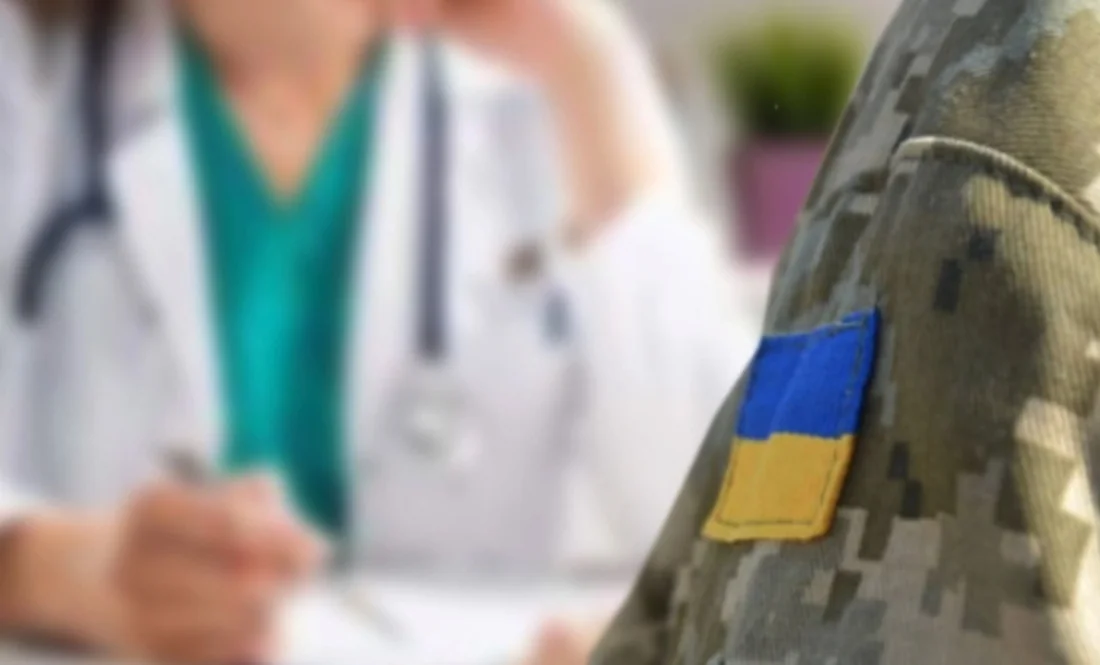 Ветеран-невролог у камуфляжі з прапором України на тлі лікаря