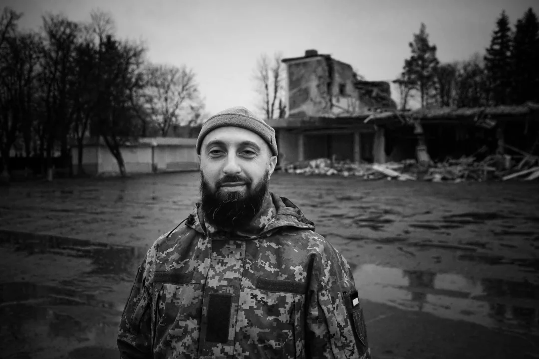 Максим Шварцман у камуфляжі на тлі зруйнованих будівель Бахмута